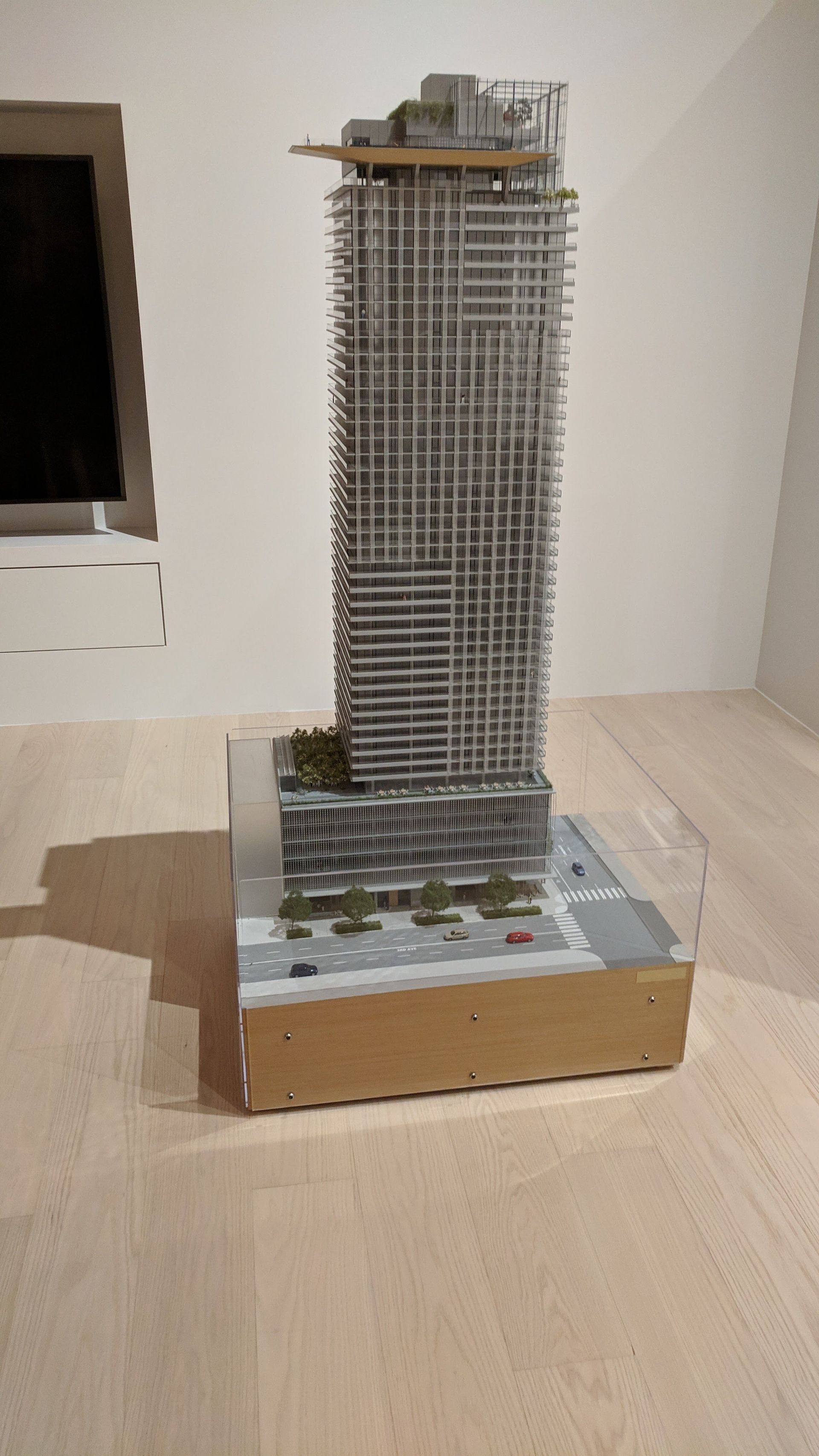 A model of a tall building is sitting on a wooden table.