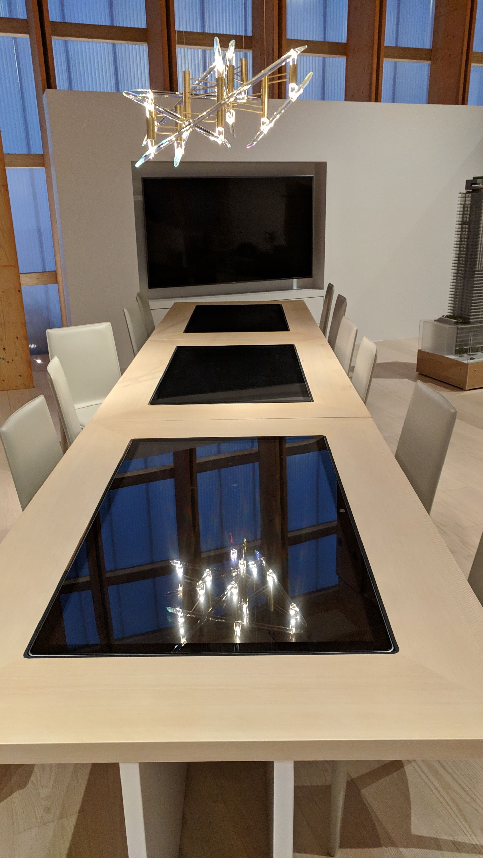 A long table with chairs and a television in a conference room.