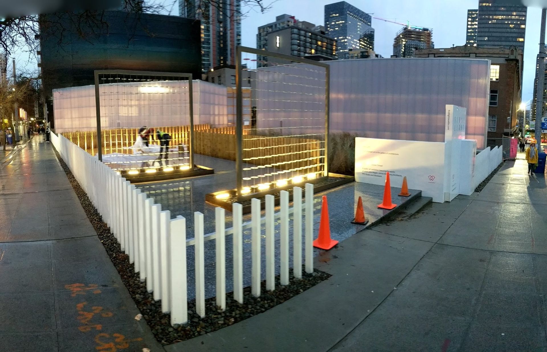 A white picket fence surrounds a building that is under construction