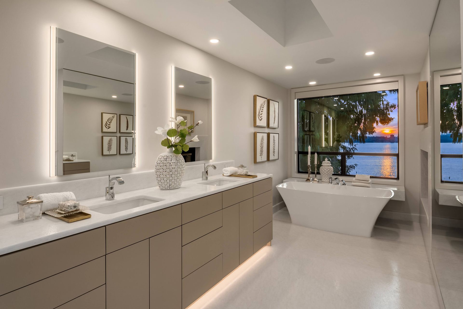A bathroom with two sinks , two mirrors and a bathtub.