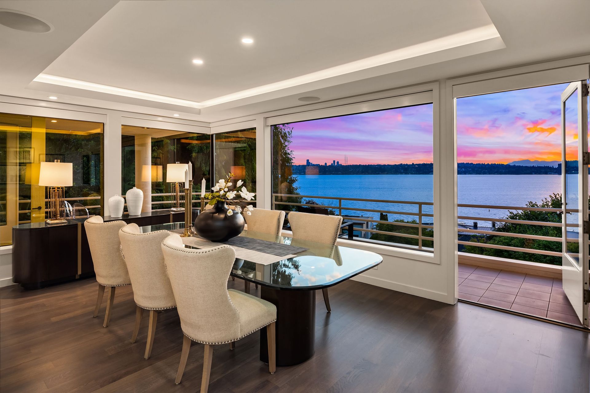 A dining room with a table and chairs and a view of the ocean.