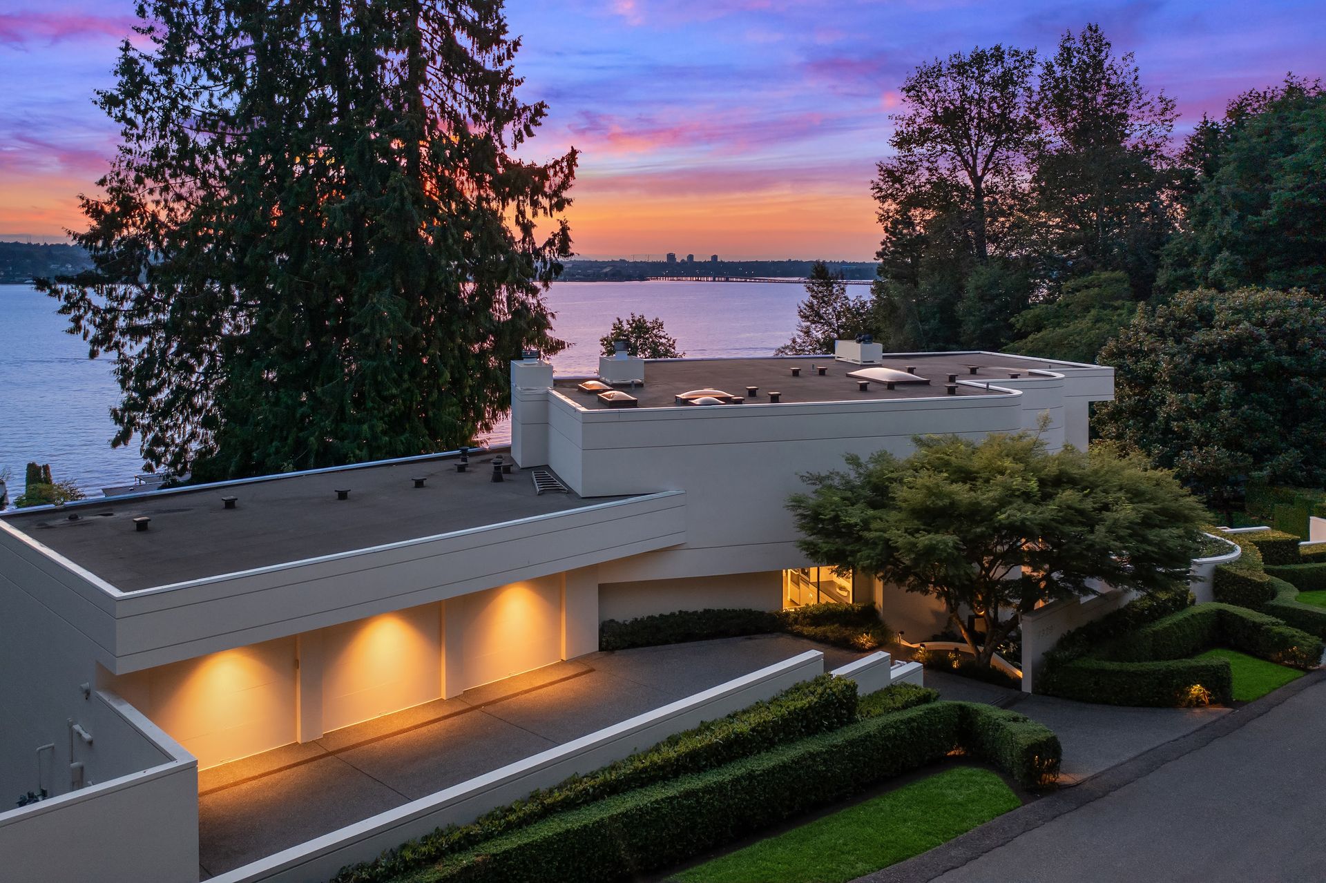 An aerial view of a house with a view of the water at sunset