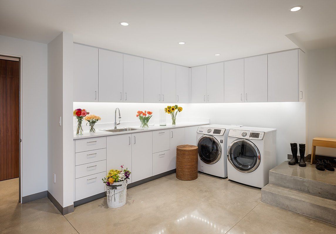 A laundry room with a washer and dryer and a sink.