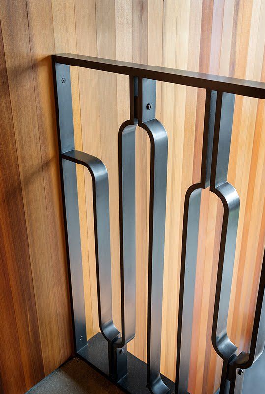 A close up of a metal railing on a wooden wall