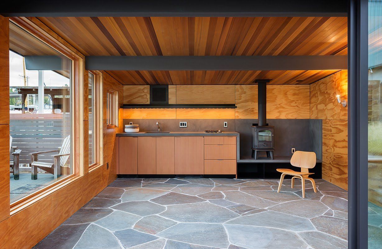 A kitchen with a wood stove and a chair in it.