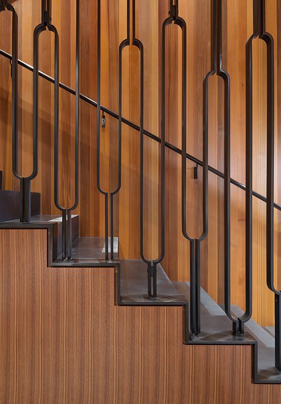A close up of a wooden staircase with a metal railing.