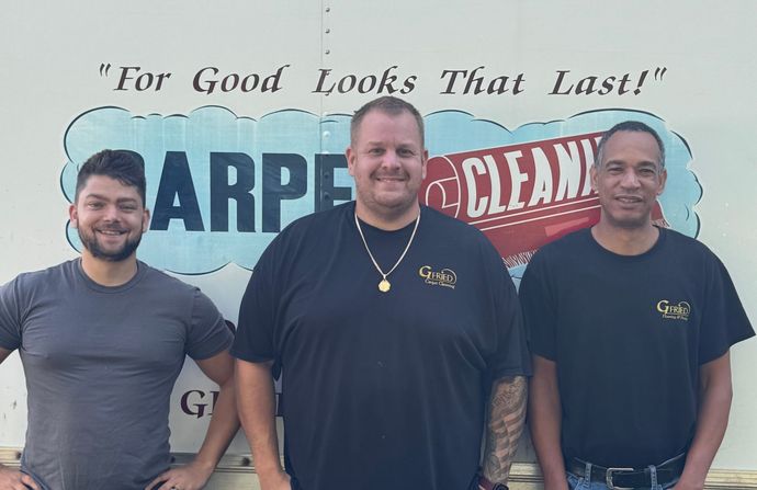 Three men are standing in front of a sign that says 