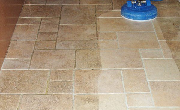 A tile floor is being cleaned with a machine.