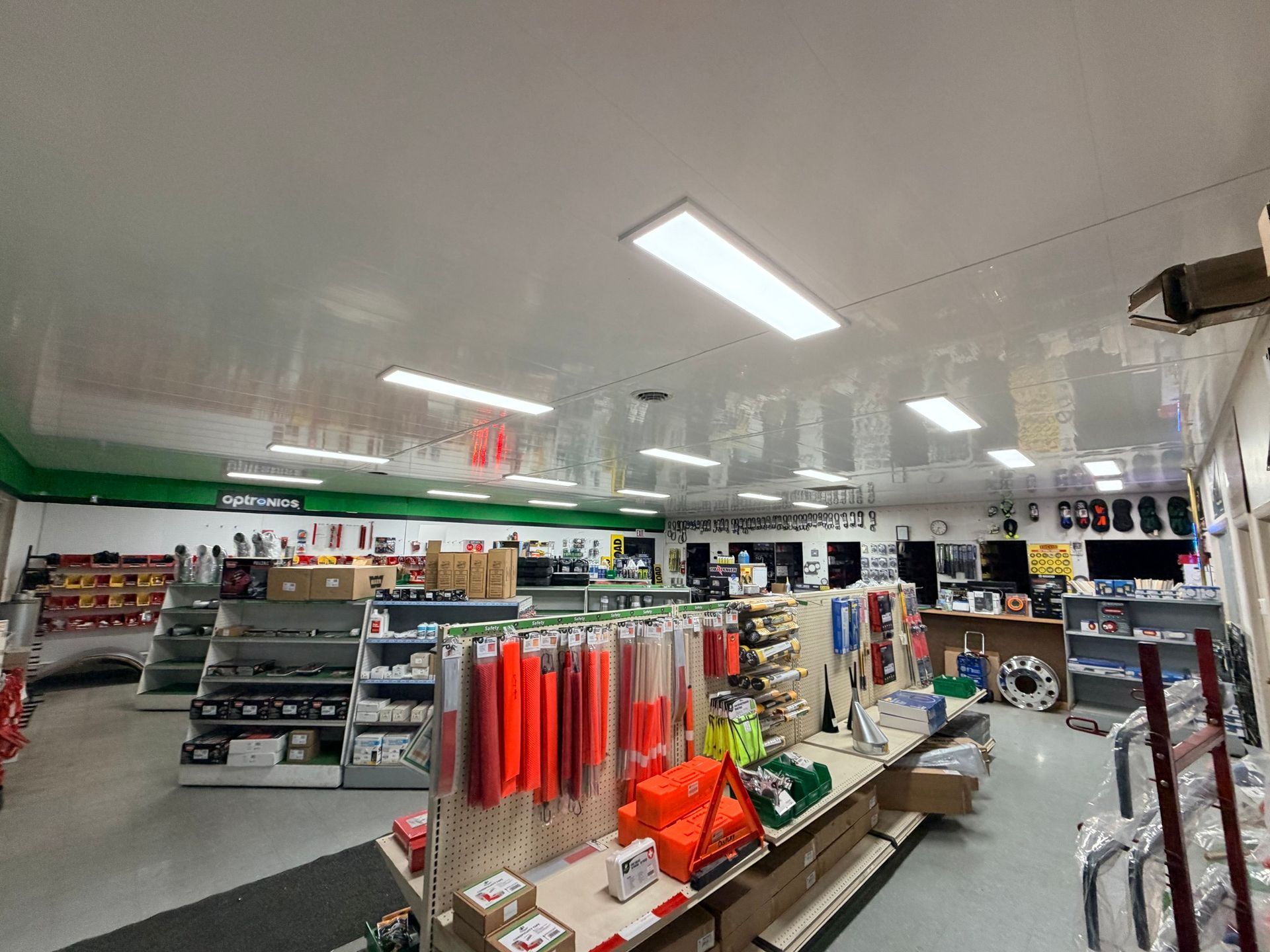 A bright convenience store aisle with shelves of snacks, drinks, and household items.