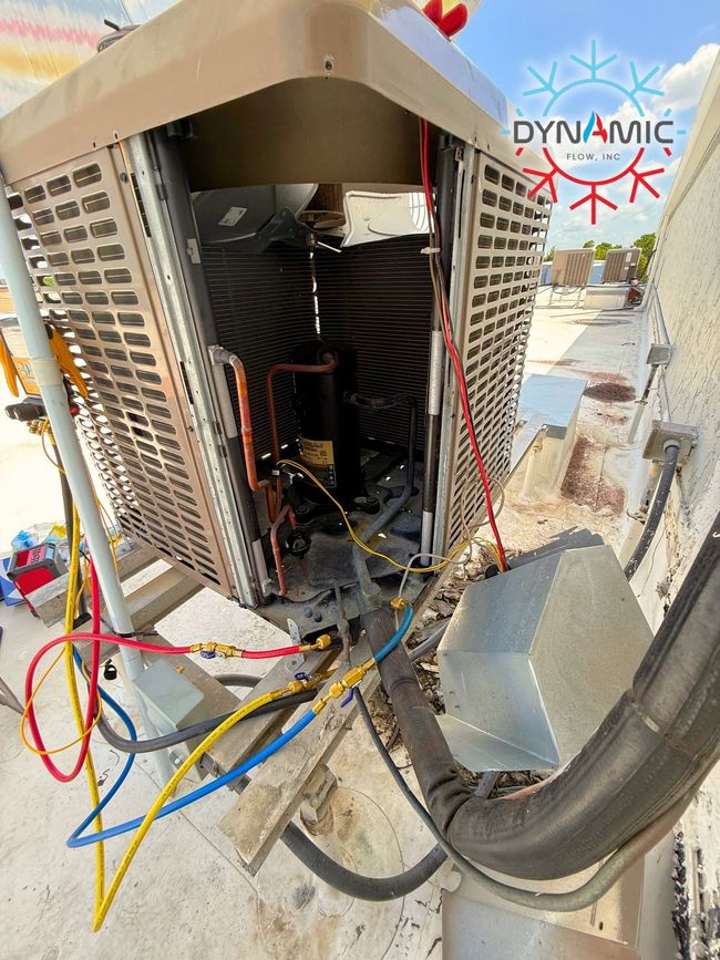 Open HVAC unit with exposed wires and components, outdoor rooftop setting