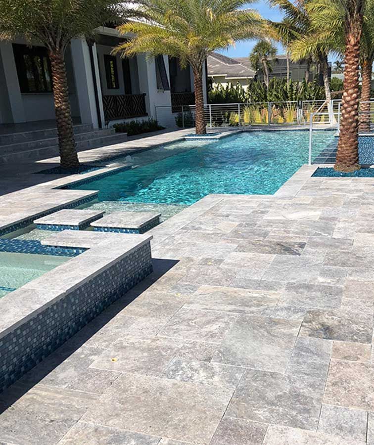 Silver travertine outdoor pavers showing natural pores, veining, and tight joints