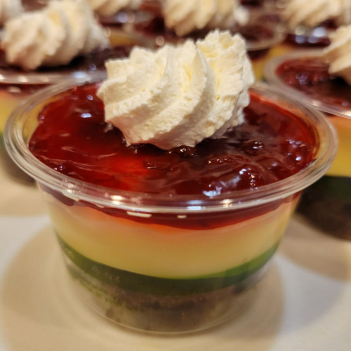 Cup of glossy dark cherries on a dessert parfait with green-striped sides