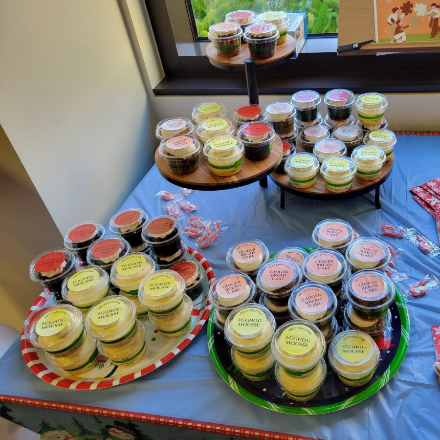 Assorted cupcakes on trays and a table with folded napkins and a red cloth by a window