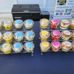 Dessert cups displayed on trays beside a black printer and a QR-code sign at a market booth