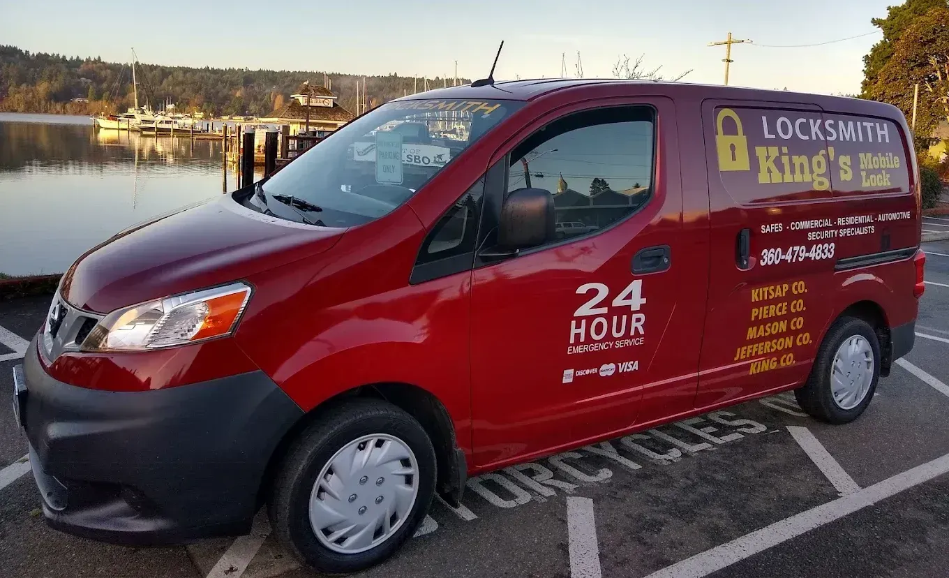 Red locksmith van parked outdoors at dusk, branded “24 Hour Locksmith King’s.”