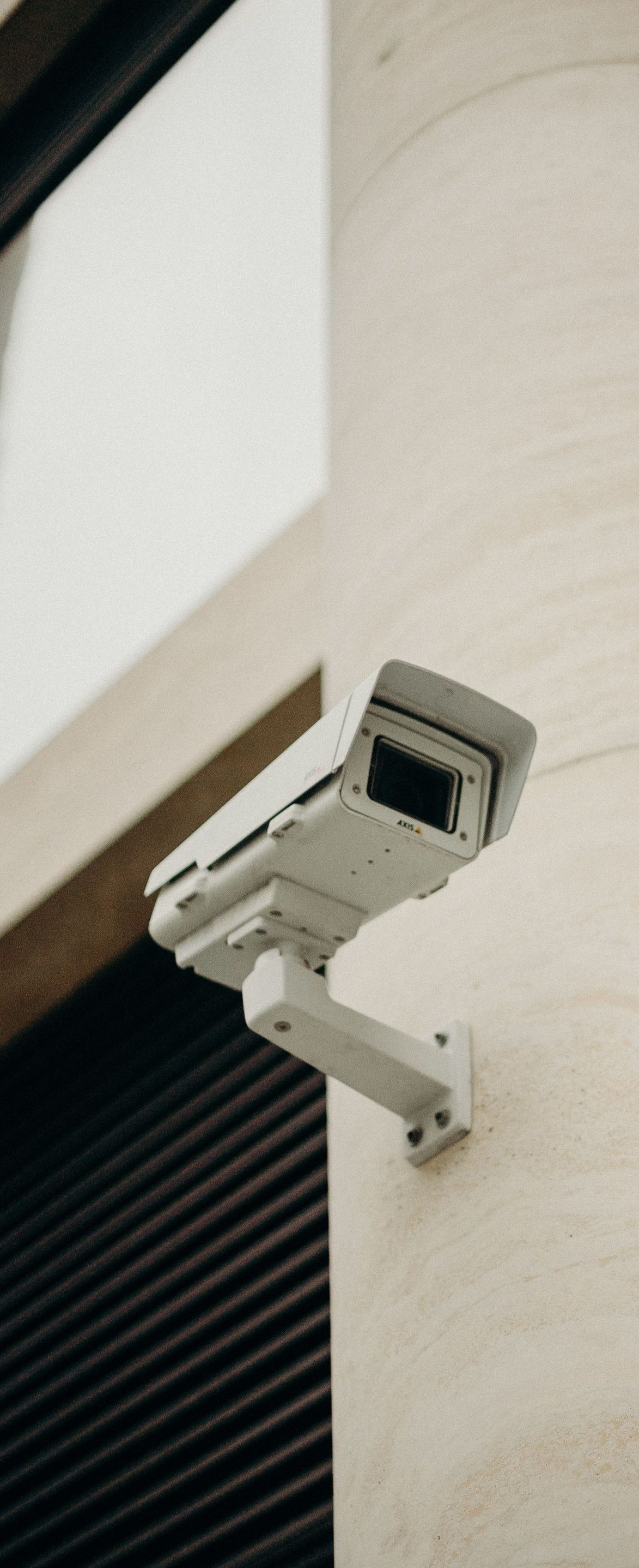 Security camera mounted on a building wall under an overhang