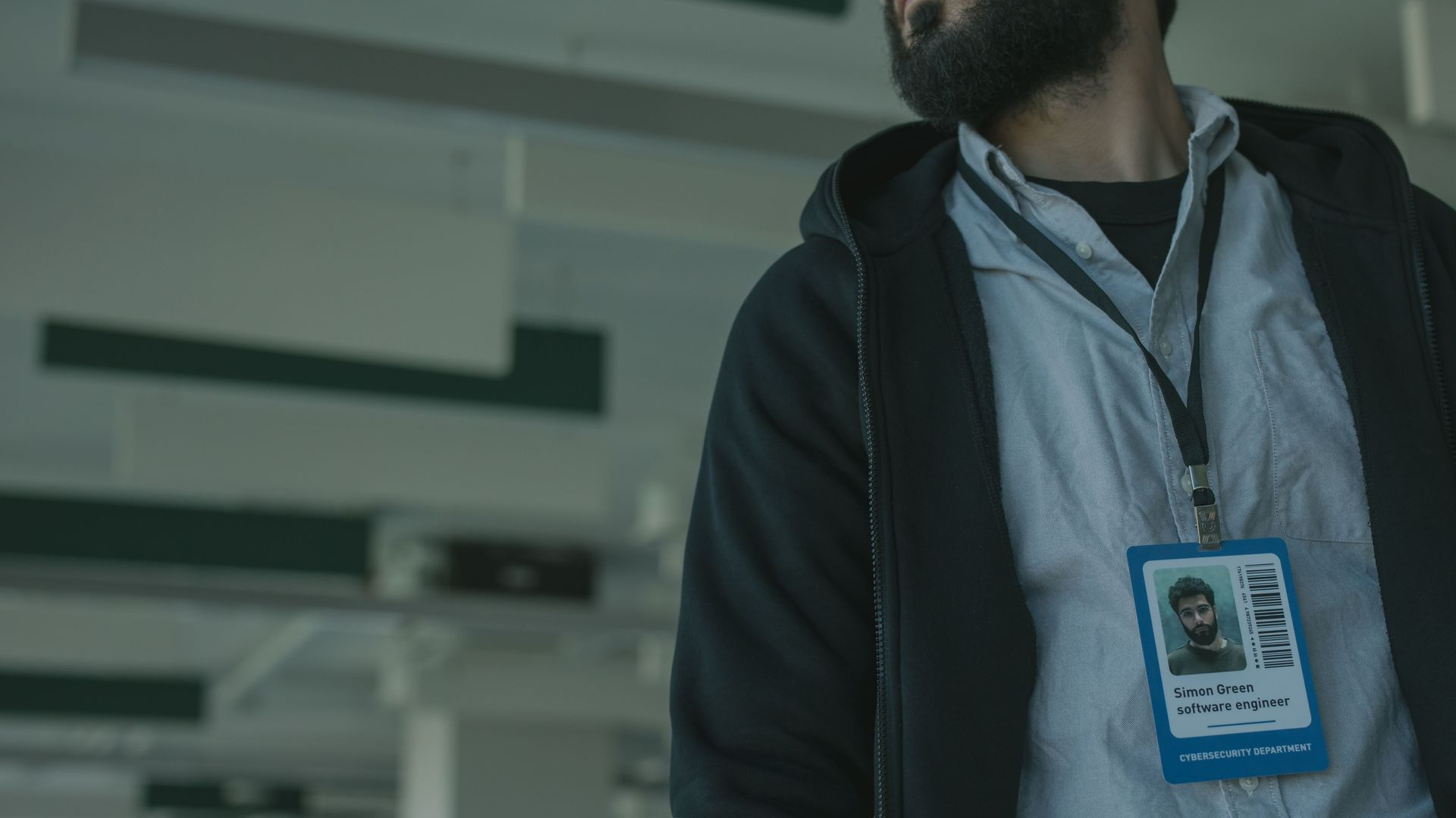 Person wearing a blue lanyard badge in an indoor office setting, looking upward