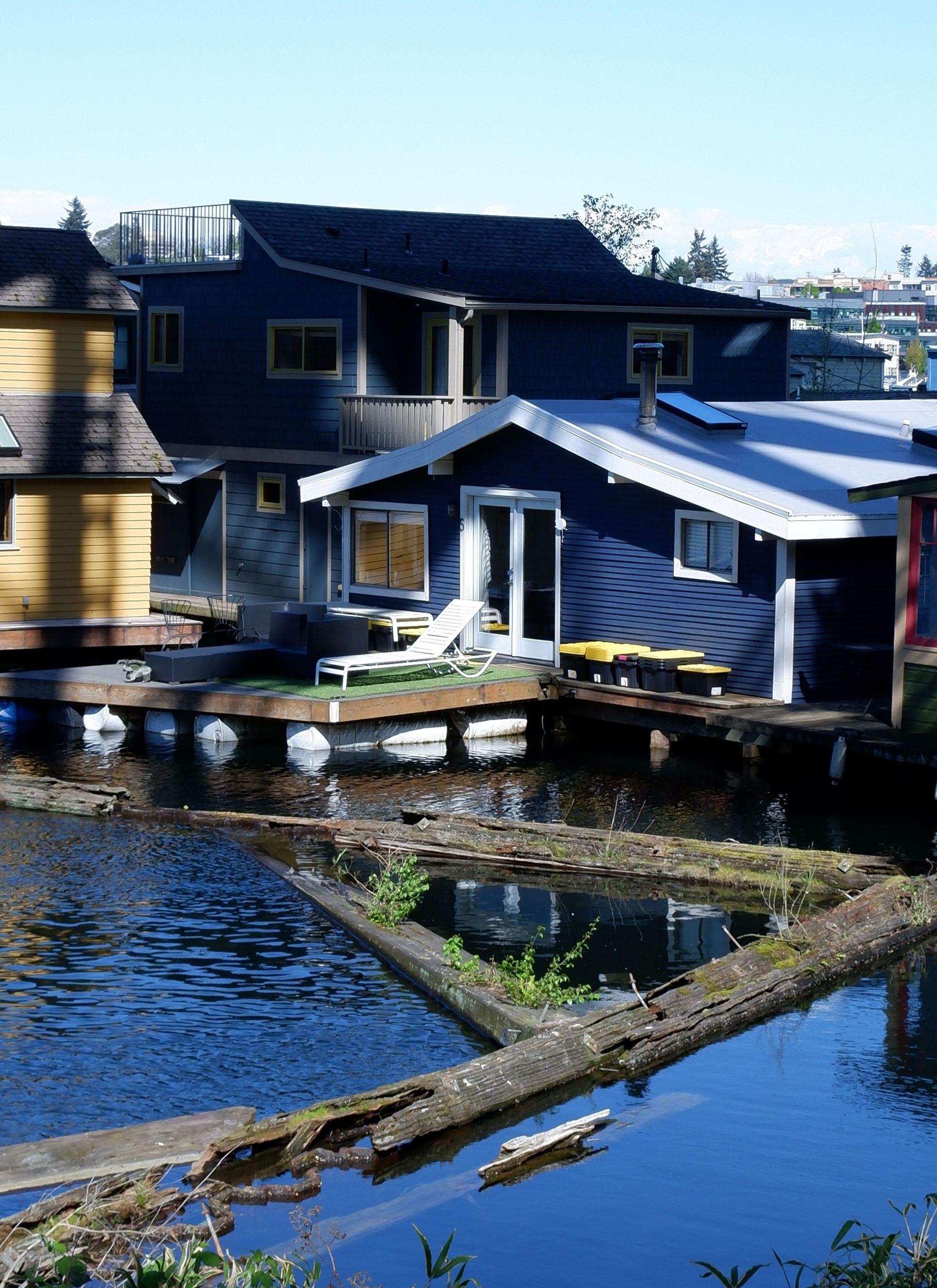 Blue waterside house with dock and reflections on the water
