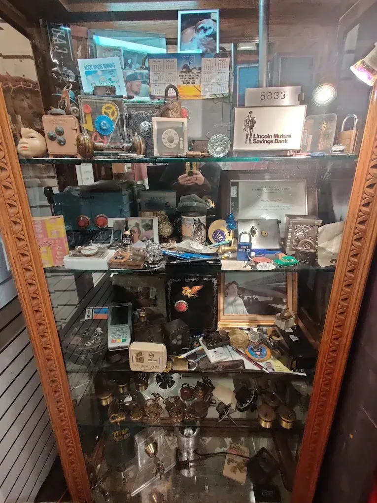 A glass display cabinet filled with various small objects and memorabilia.