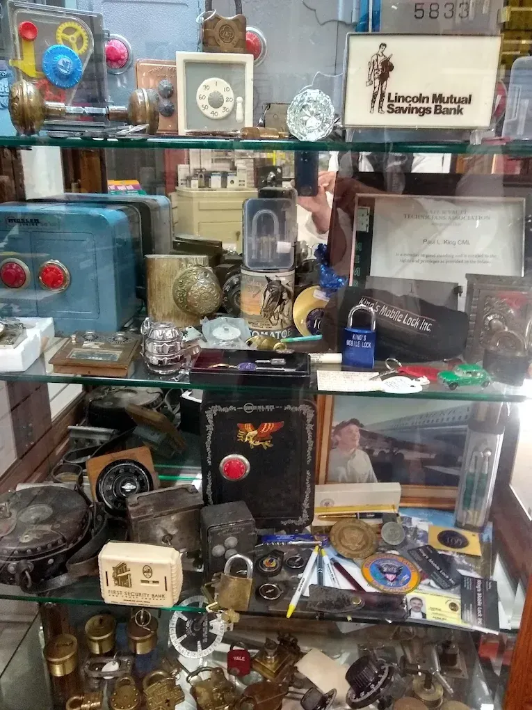A glass display case filled with antique locks, safes, and memorabilia.