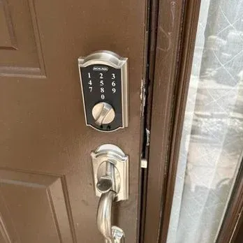 A brown door with a Schlage keypad lock and a silver handle.