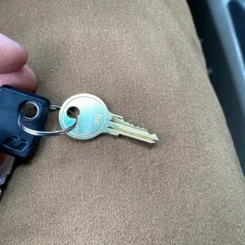 Close-up of keys on fabric. One silver key with teeth and black-handled key on a ring.