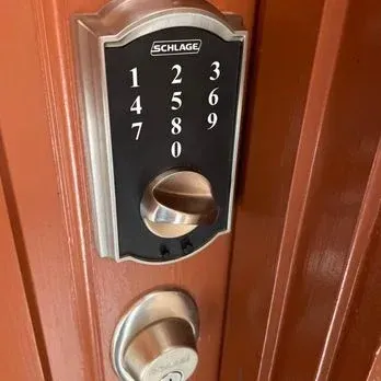 Schlage keyless entry lock on brown door with a standard deadbolt below.