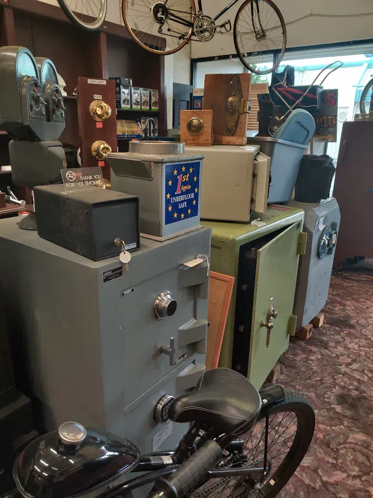 Collection of antique safes and vintage bicycle in a shop.