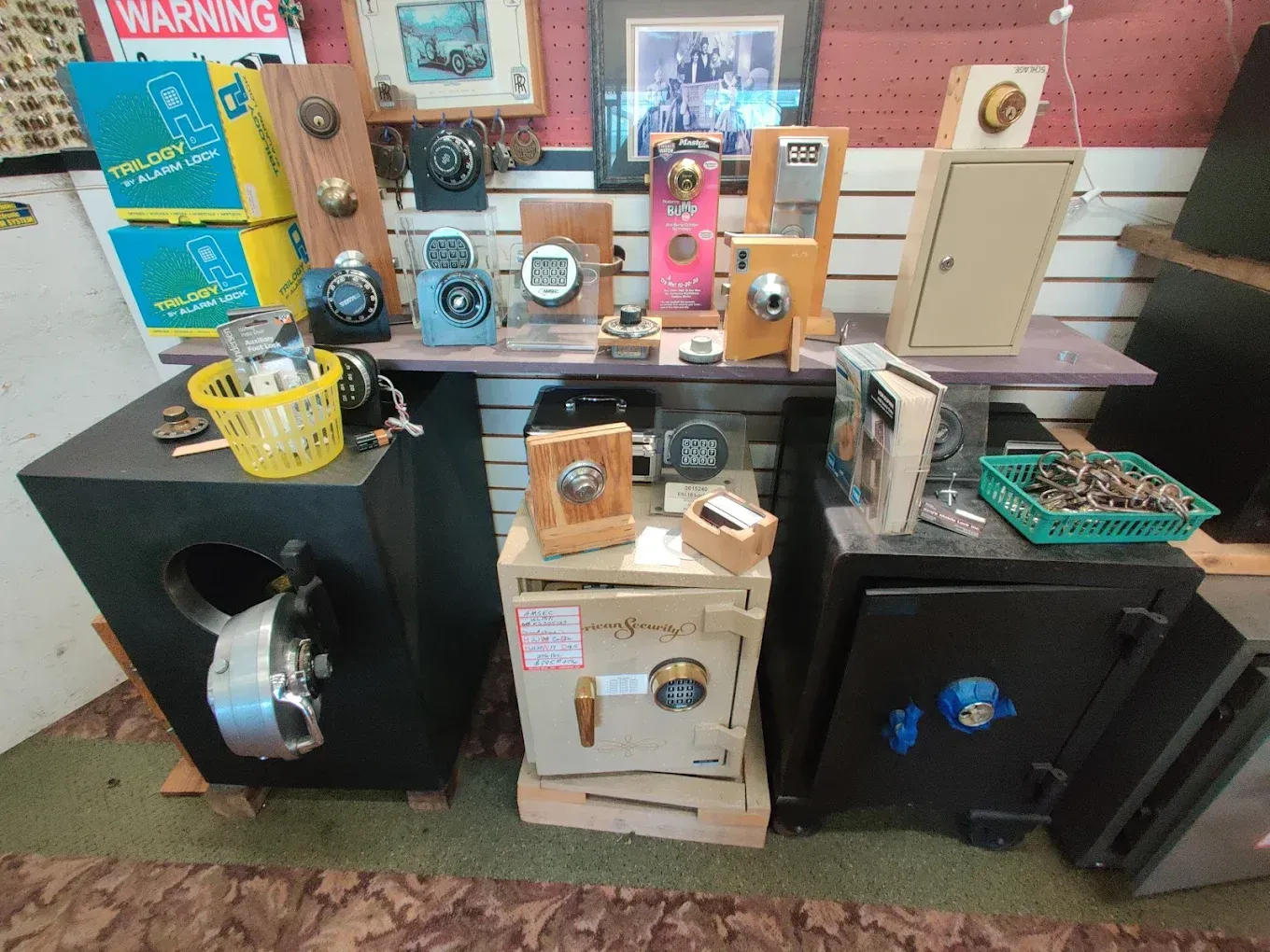 Antique locks and safes in various shapes, sizes, and colors displayed on shelves and wooden structures.