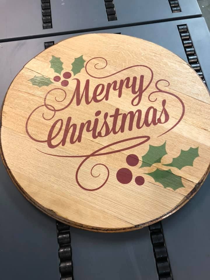 A wooden sign that says merry christmas is sitting on a table.