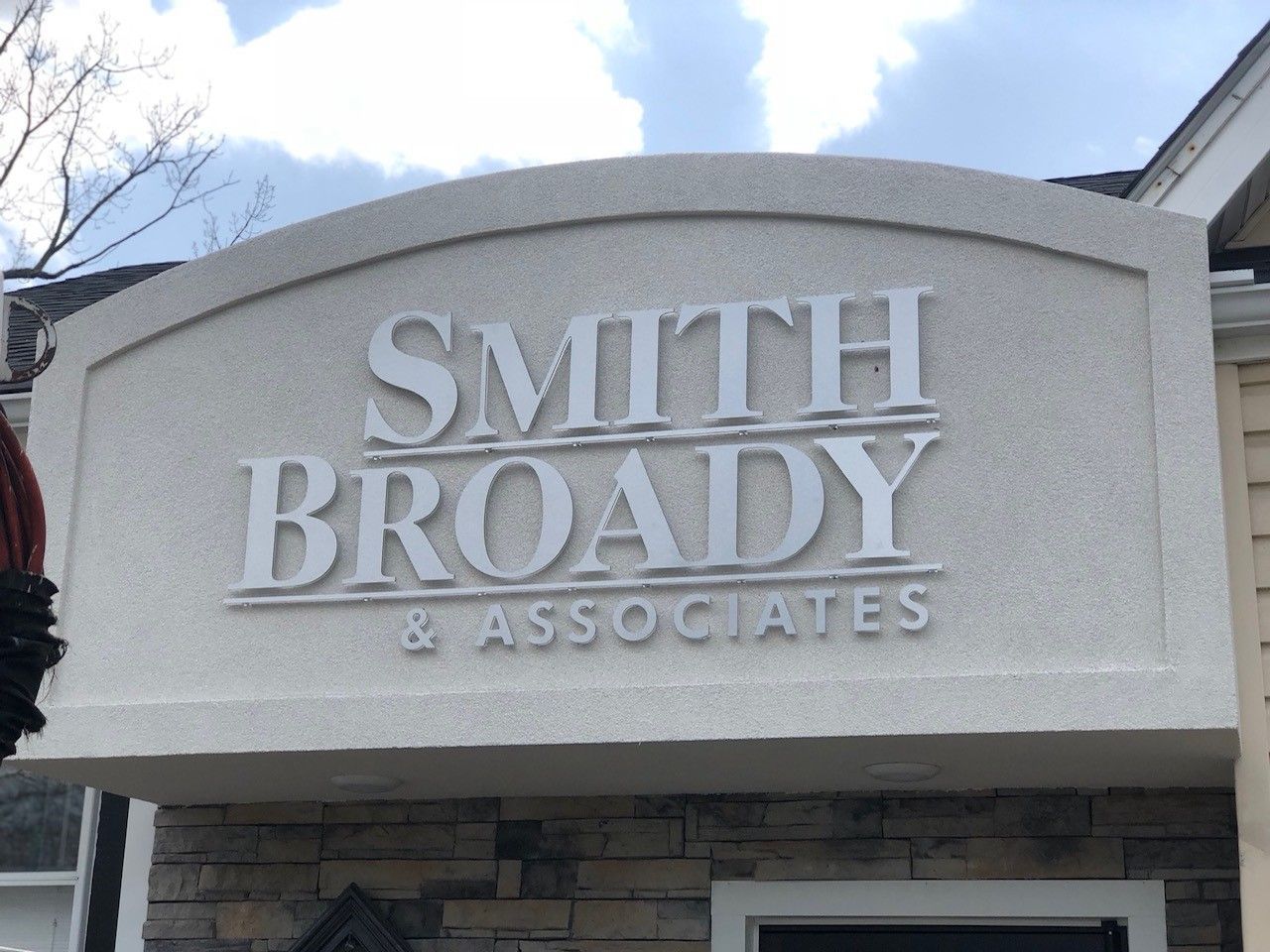 White dimensional lettering on a textured sign reading