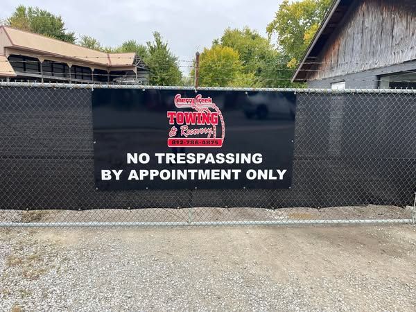 A black fence features a sign that reads: