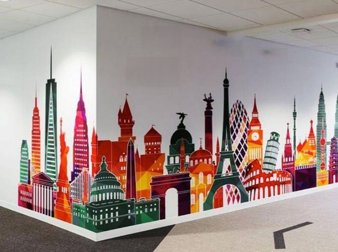 A colorful wall mural featuring iconic global landmarks and skyscrapers against a clean white background.