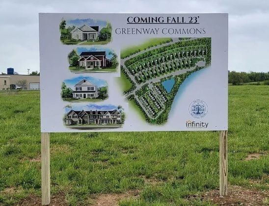 A sign in an open field promoting