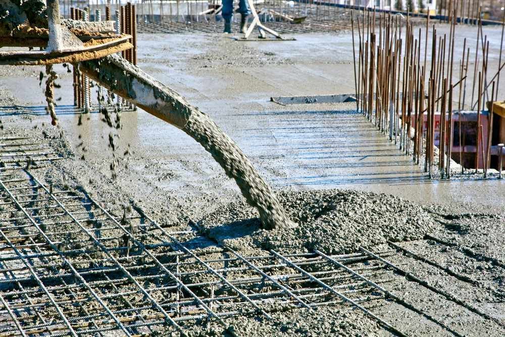 A Concrete Pump Is Pouring Concrete On A Construction Site — C R Concreting in Chinchilla, QLD