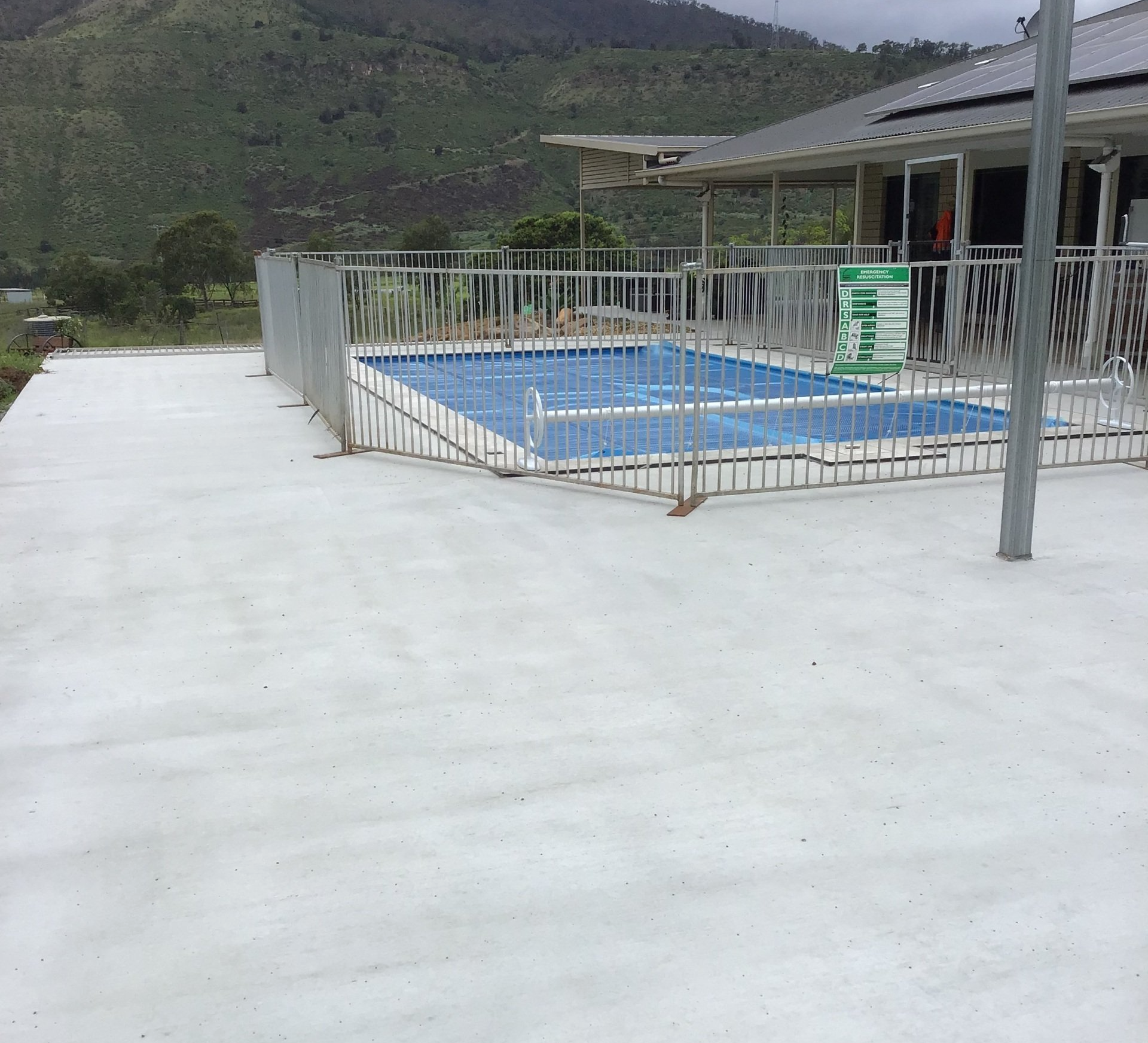 A Large Swimming Pool With a Fence Around It — C R Concreting in Pittsworth, QLD