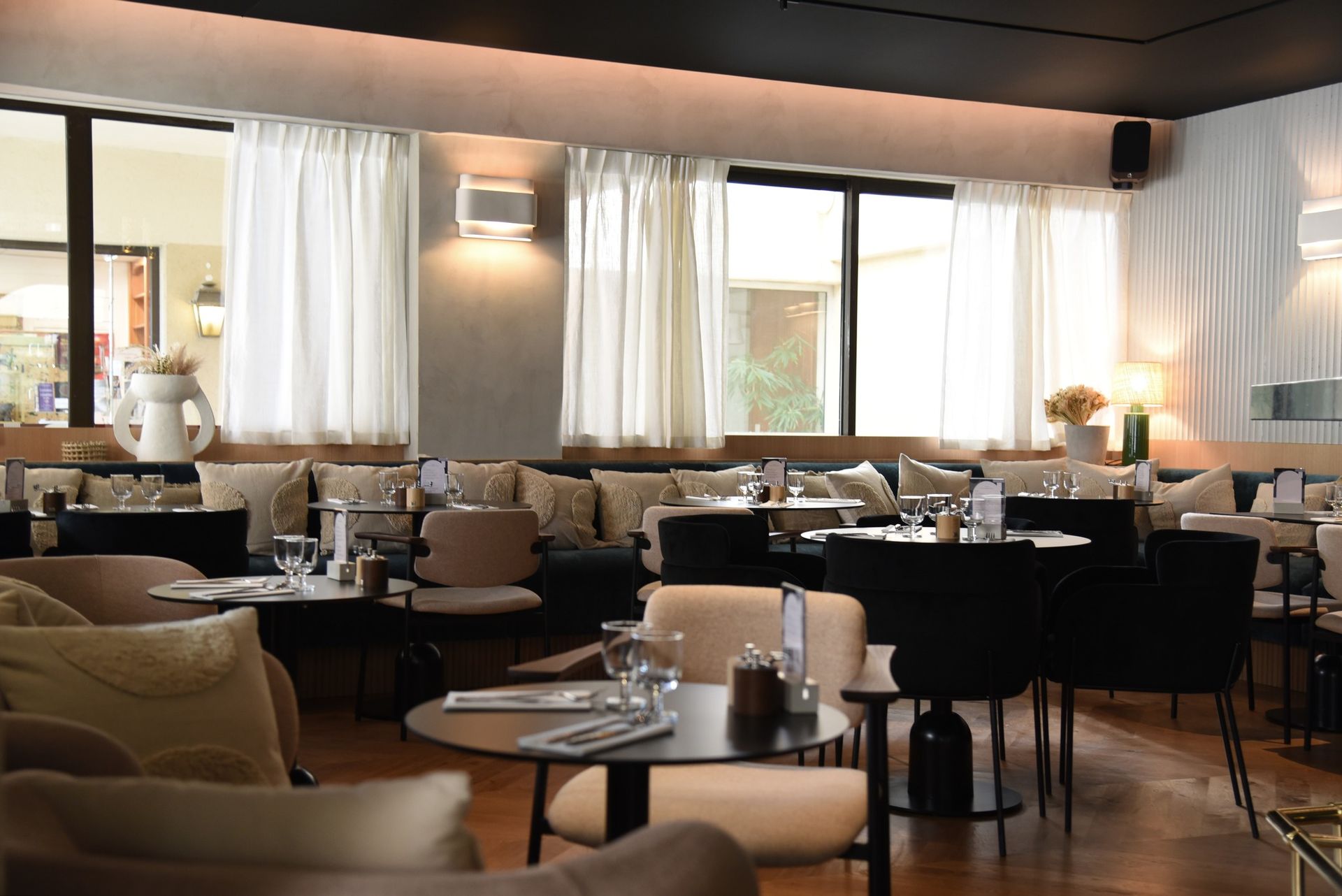 Un restaurant avec des tables et des chaises et beaucoup de fenêtres