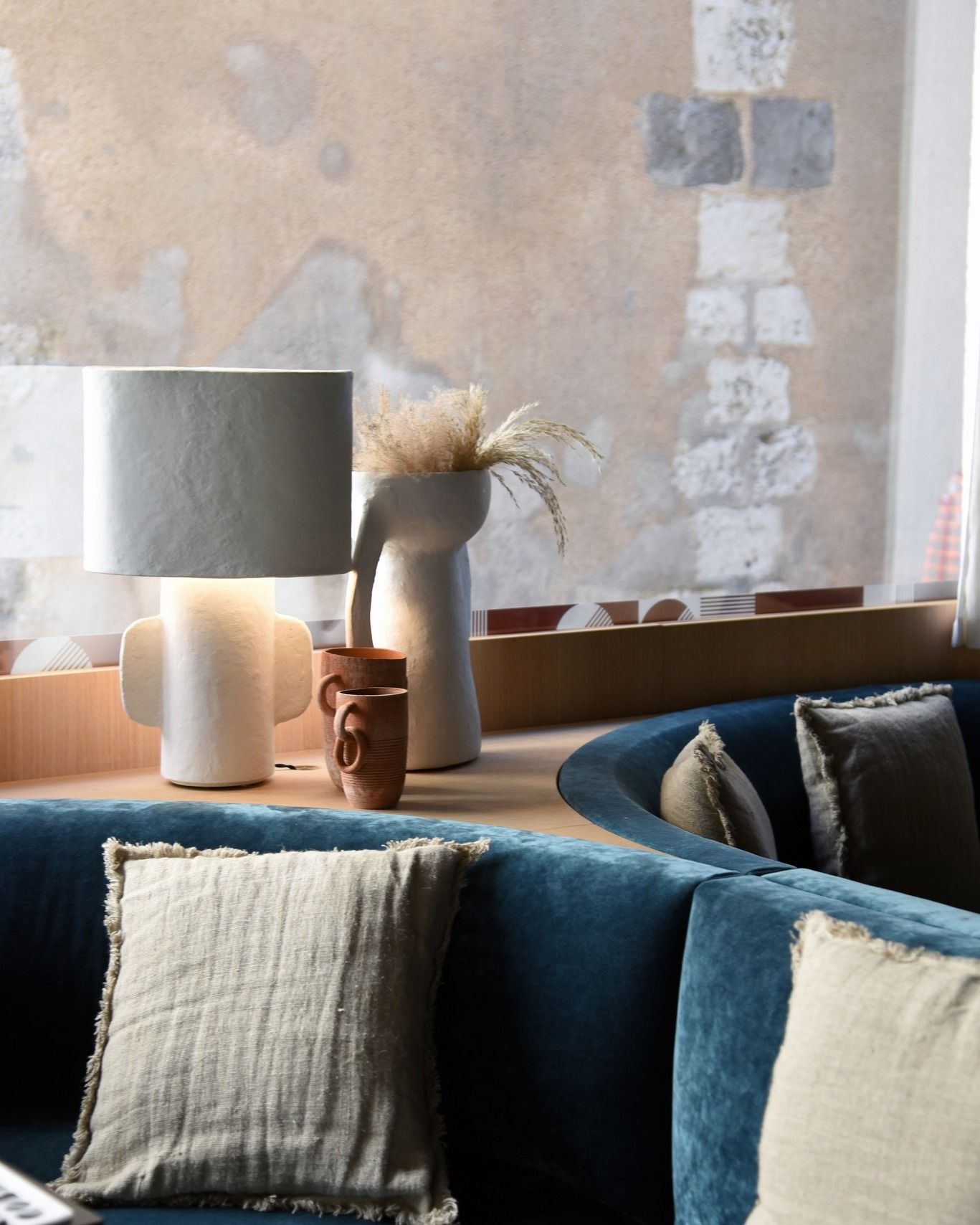 Un salon avec un canapé bleu et une lampe