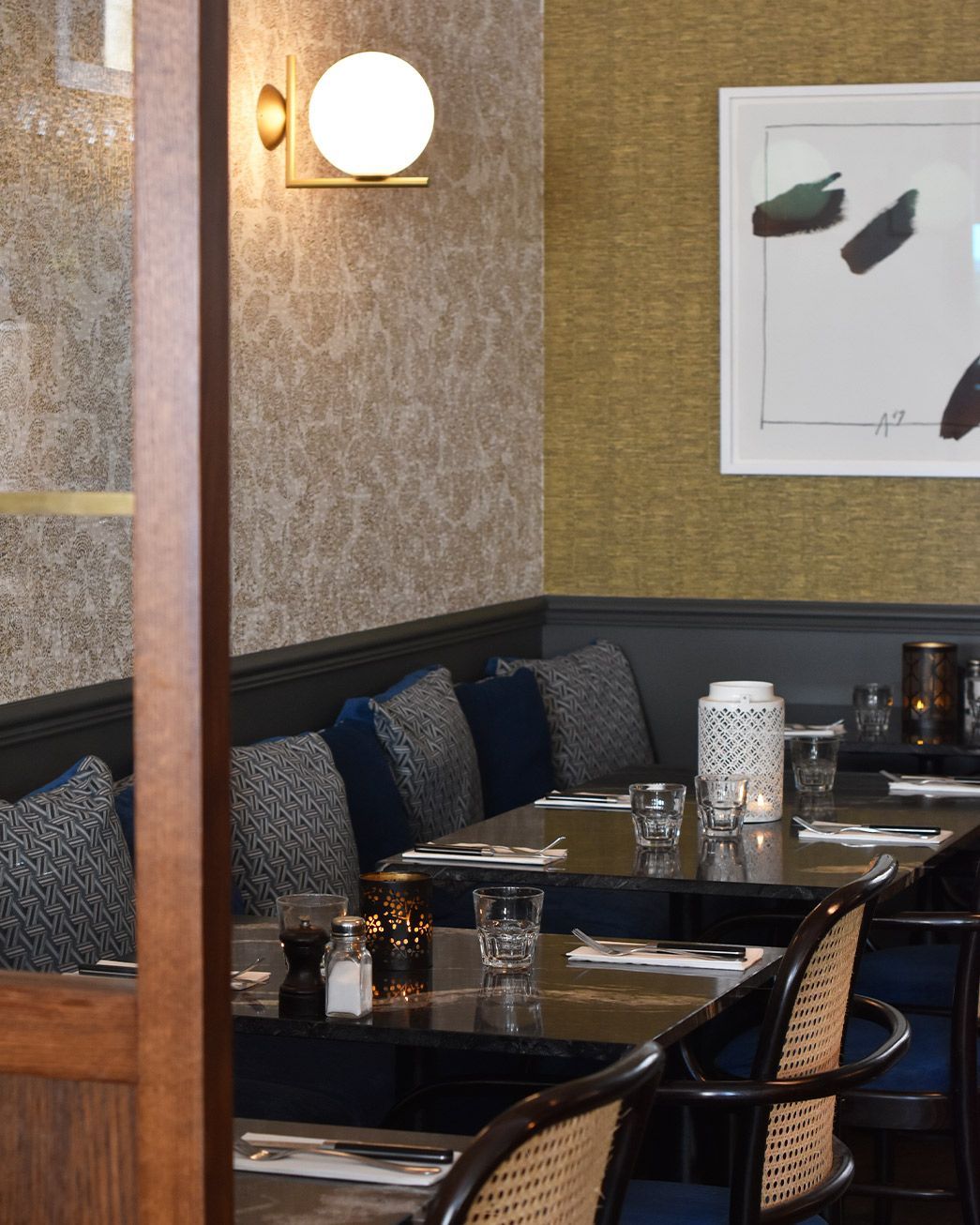 Un restaurant avec des tables et des chaises et un tableau au mur