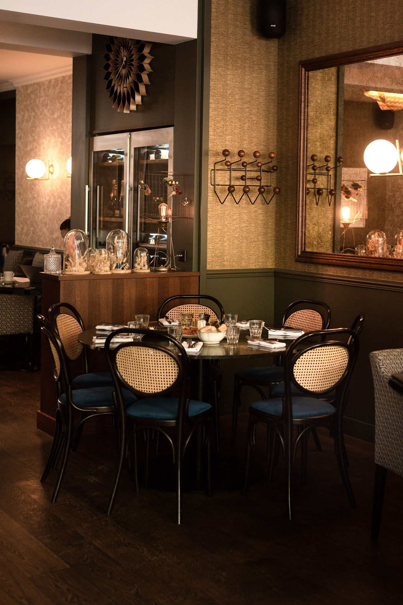Un restaurant avec des tables et des chaises et un miroir au mur.