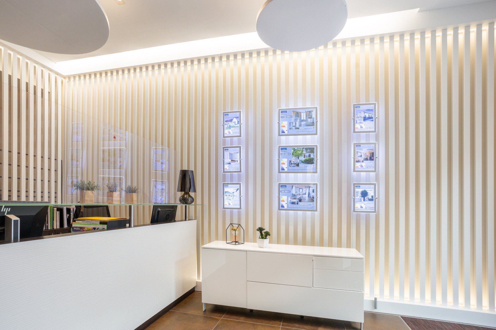 Un espace de réception avec un comptoir blanc et un mur en bois.