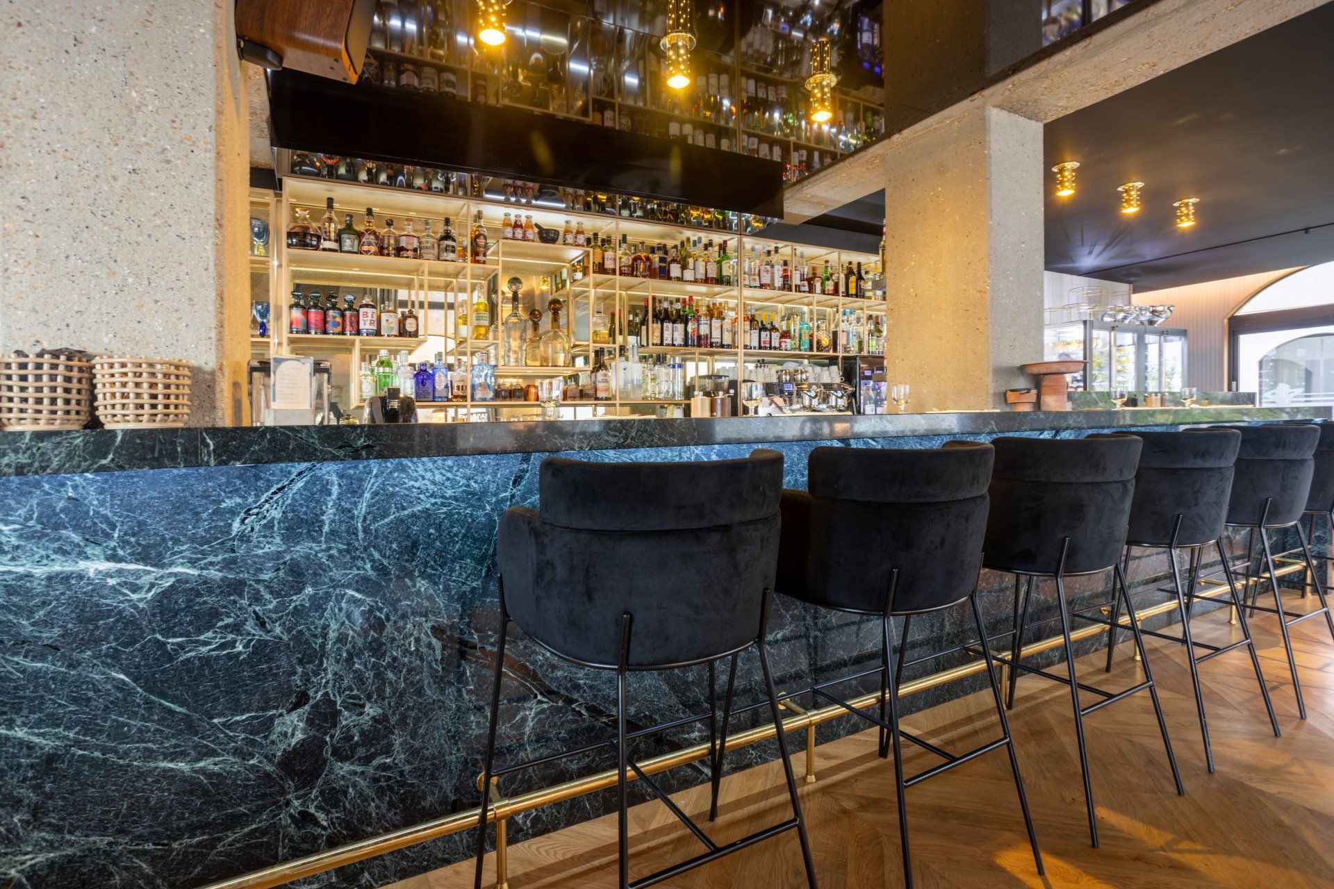 Une rangée de tabourets de bar assis à côté d'un long bar dans un restaurant.