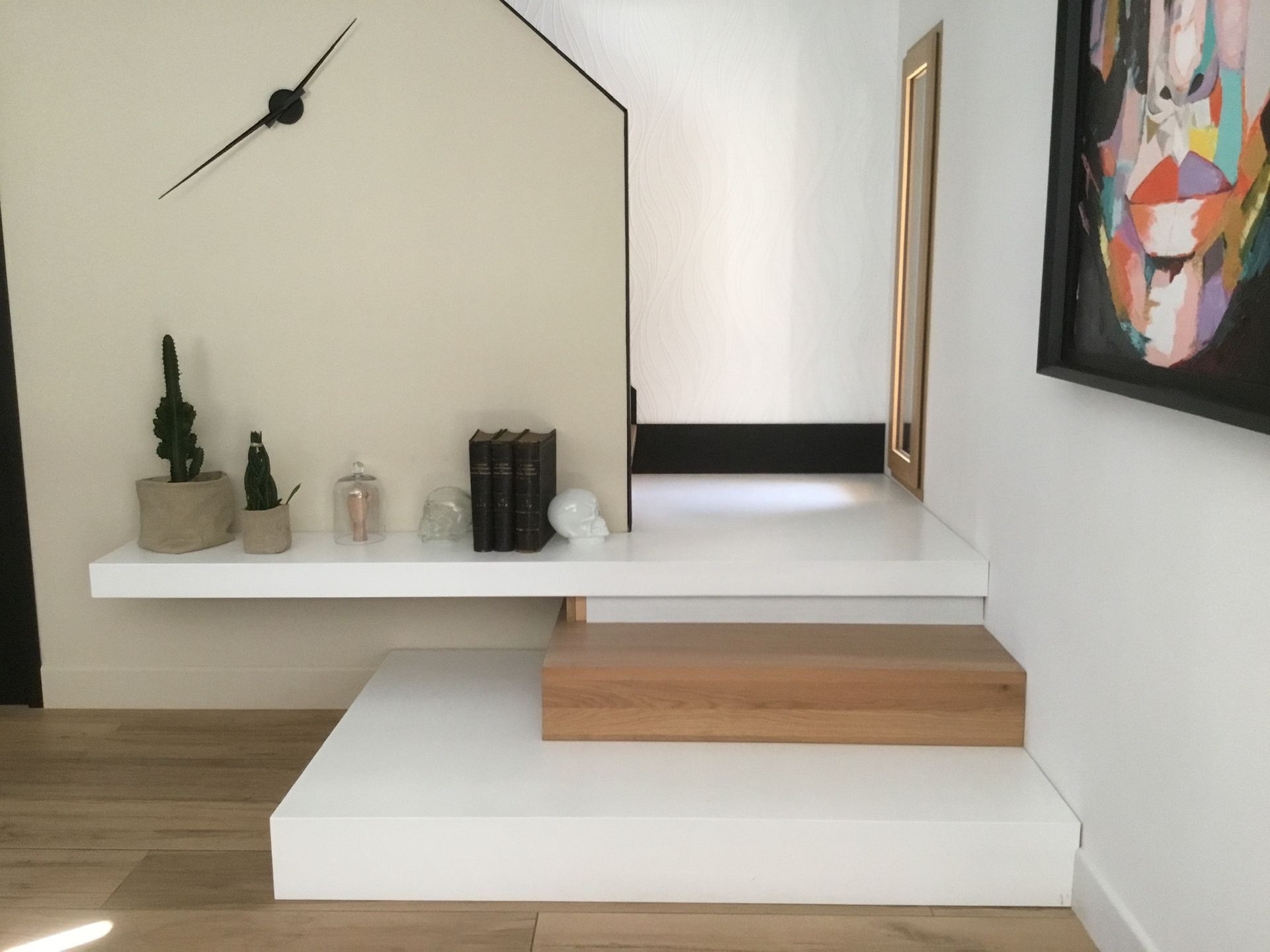 Une pièce avec une étagère et une horloge au mur