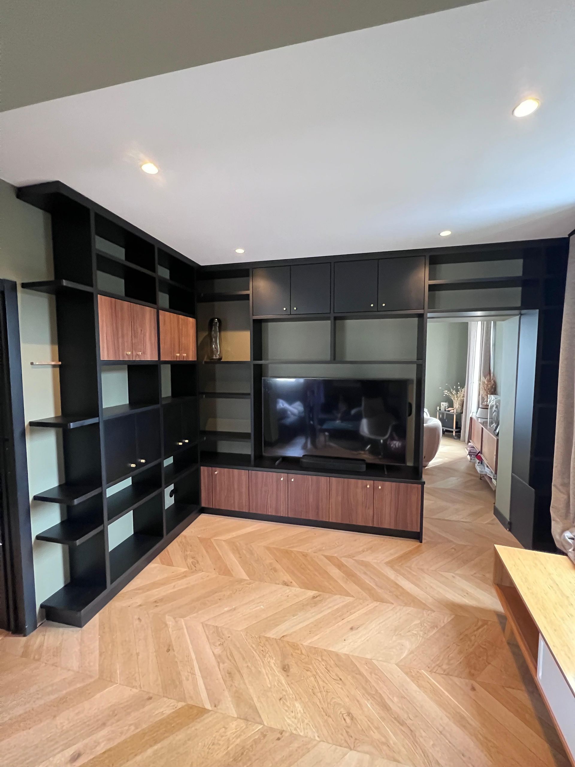 Un salon avec parquet et une télévision à écran plat