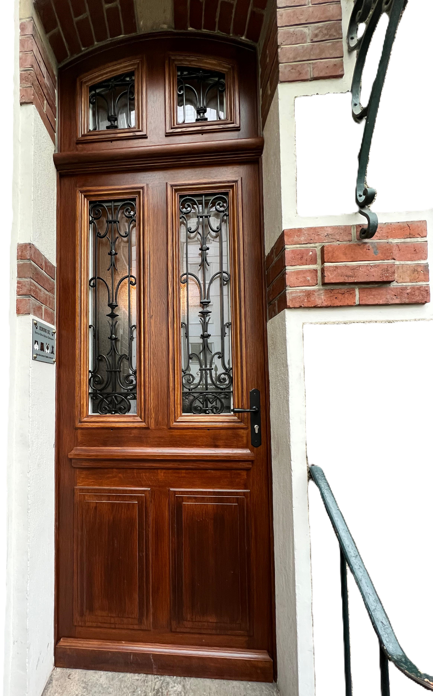 Une porte en bois avec un motif en fer forgé dessus