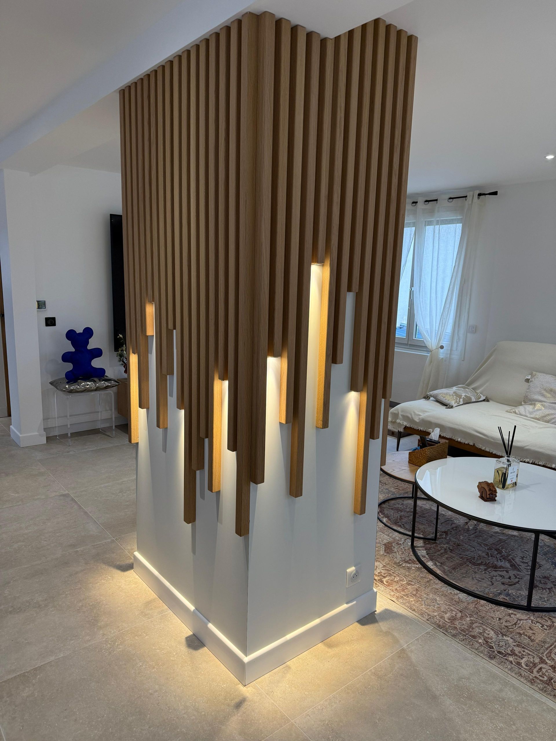 Un salon avec une cloison en bois et une table basse.