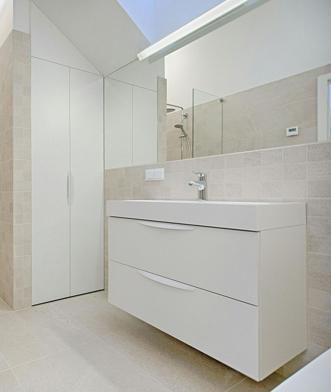 Une salle de bain avec un lavabo et un grand miroir