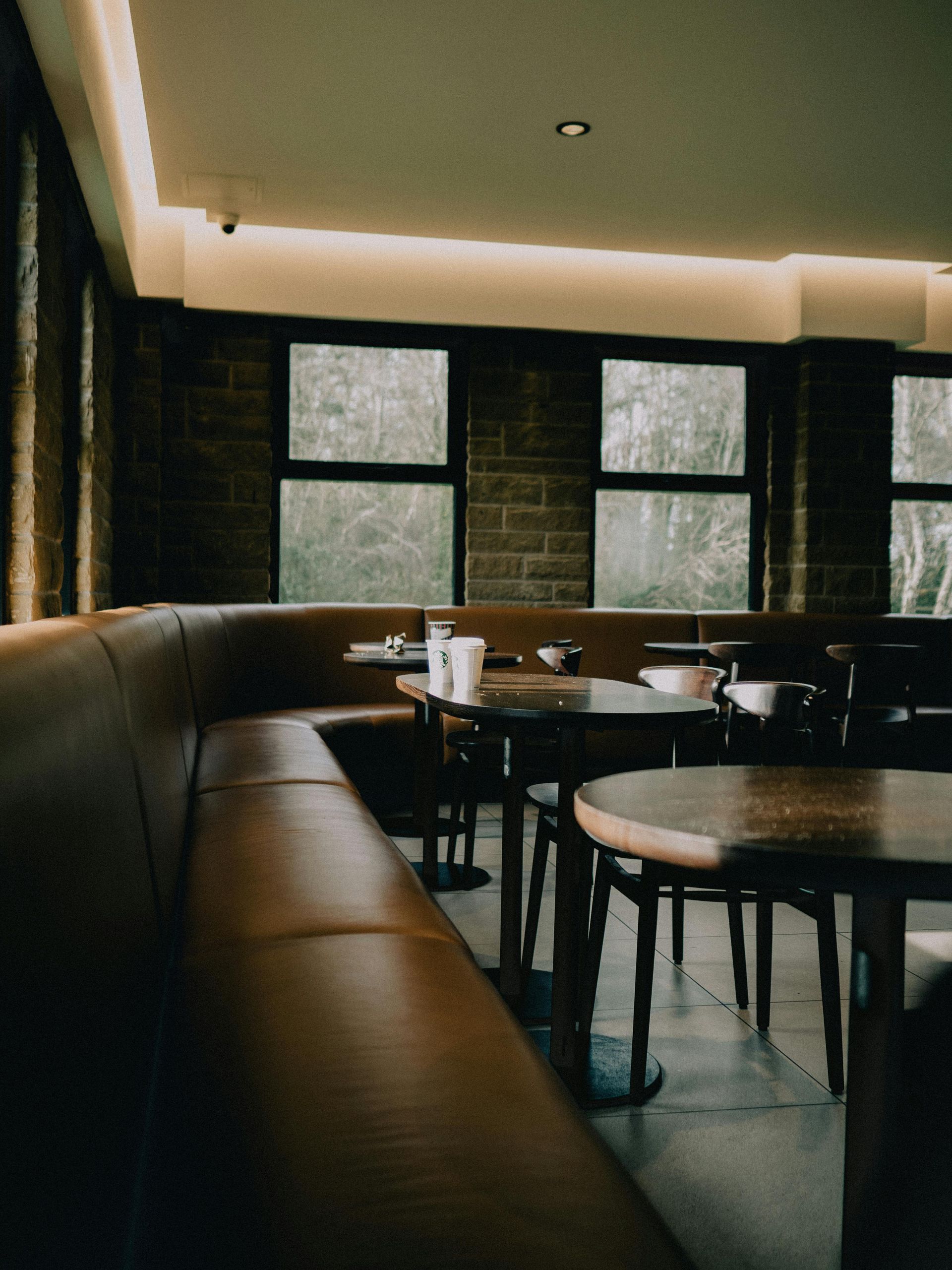 Un restaurant avec des tables et des chaises et une grande fenêtre