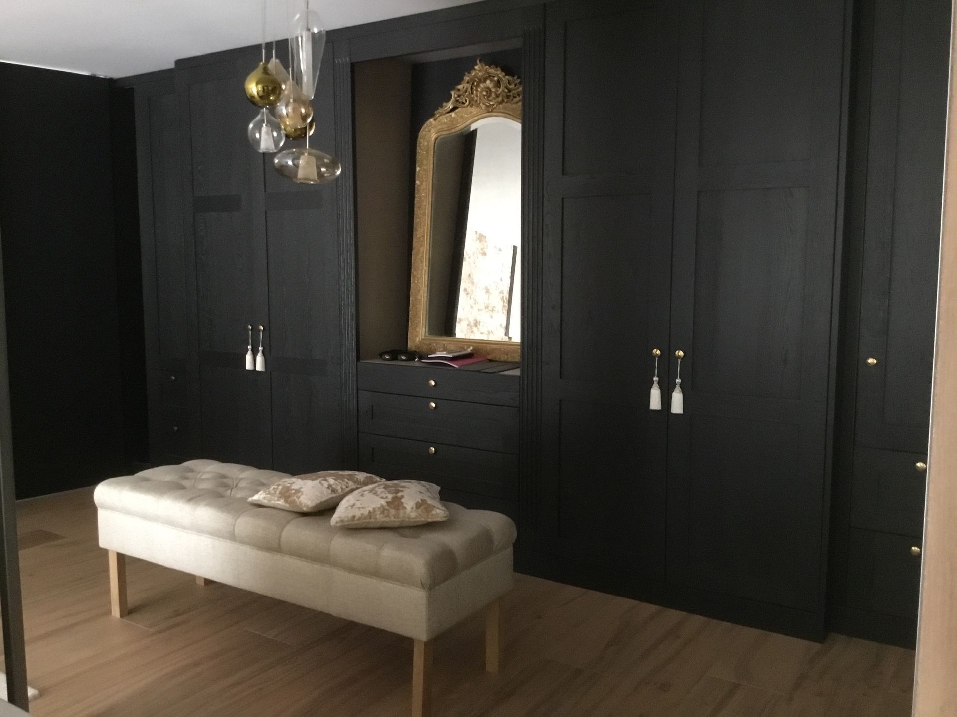 Un dressing avec un banc et un miroir