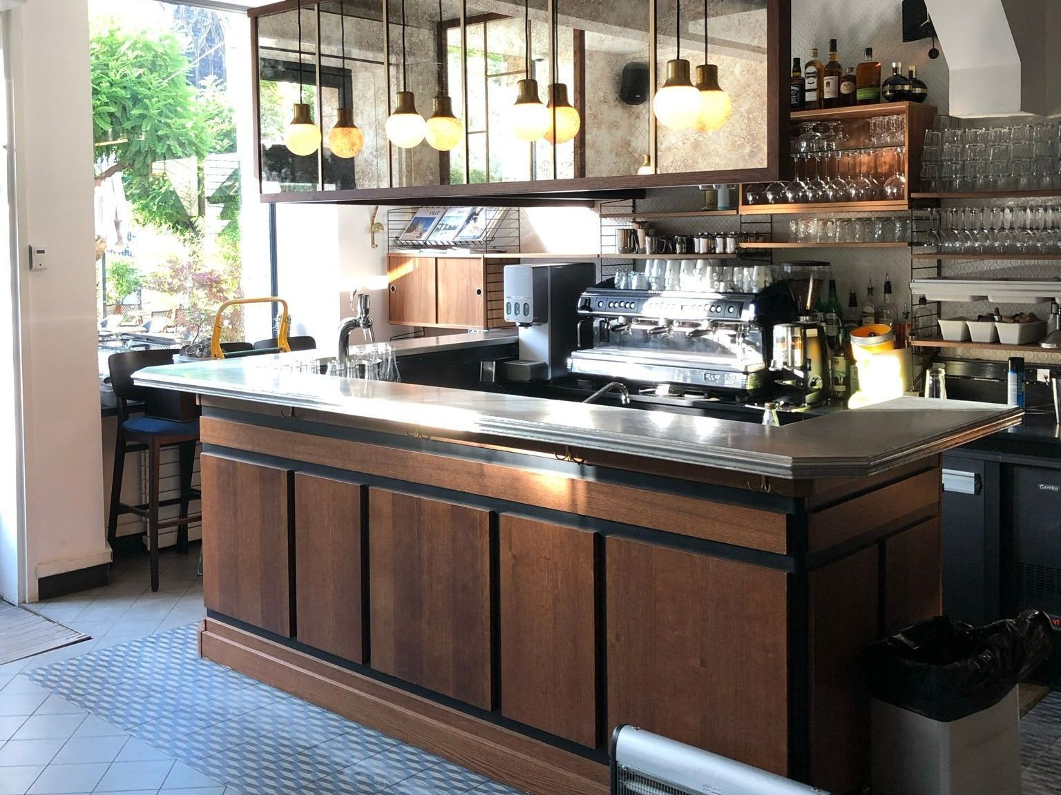 Un grand bar en bois dans un restaurant avec une machine à café.